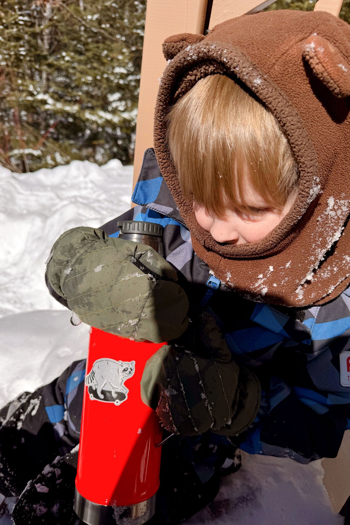 Reflective sticker of a cute racoon on a skateboard shown on a child's thermos