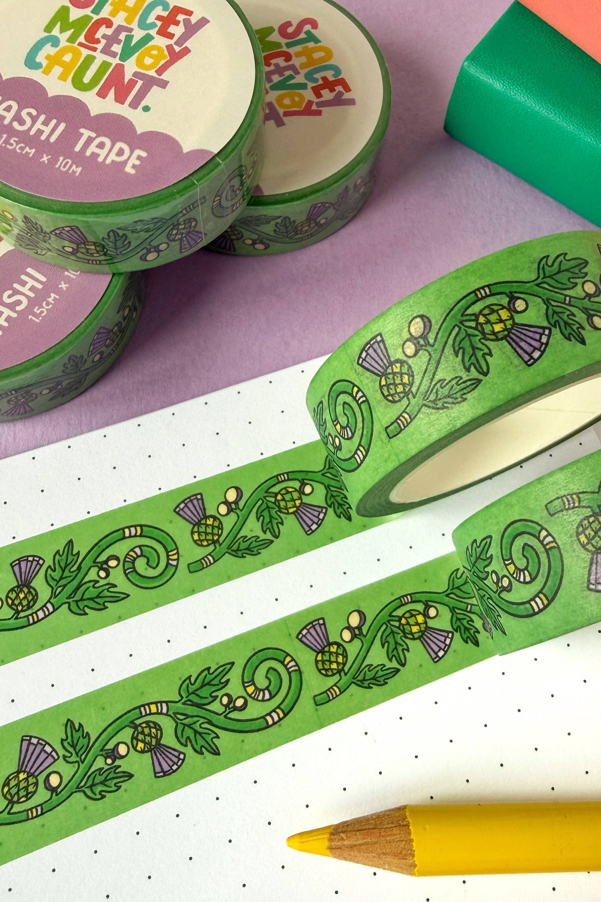 Green washi tape with decorative thistle design on a purple and white background