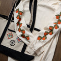 Off-white long sleeved t-shirt with cute oranges printed down the sleeves