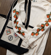 Off-white long sleeved t-shirt with cute oranges printed down the sleeves
