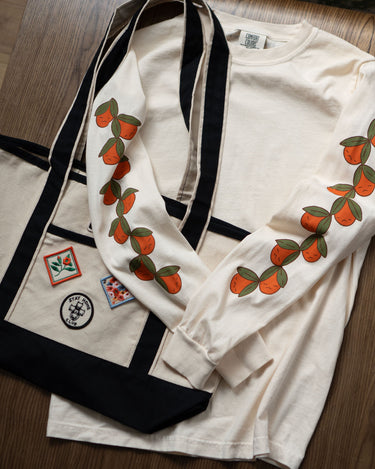 Off-white long sleeved t-shirt with cute oranges printed down the sleeves