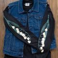 Black long-sleeved tee with lily of the valley flowers prited down the sleeves layered under a denim vest