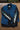Black long-sleeved tee with lily of the valley flowers prited down the sleeves layered under a denim vest