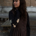 Woman wearing a dark dress with a patterned long-sleeve tee in an outdoor setting