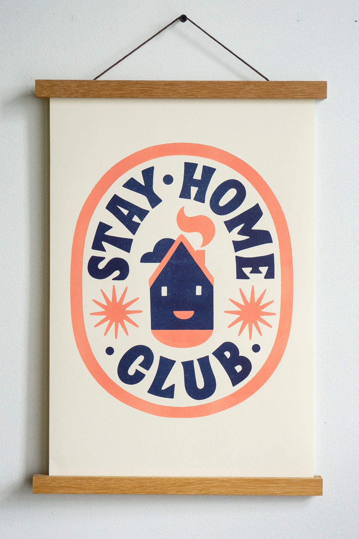 dark blue stay home club text in orange oval with house with smiley face and stars in the centre