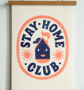 dark blue stay home club text in orange oval with house with smiley face and stars in the centre
