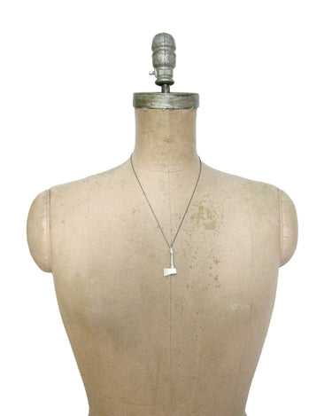 mannequin with dark chain with polished silver axe pendant